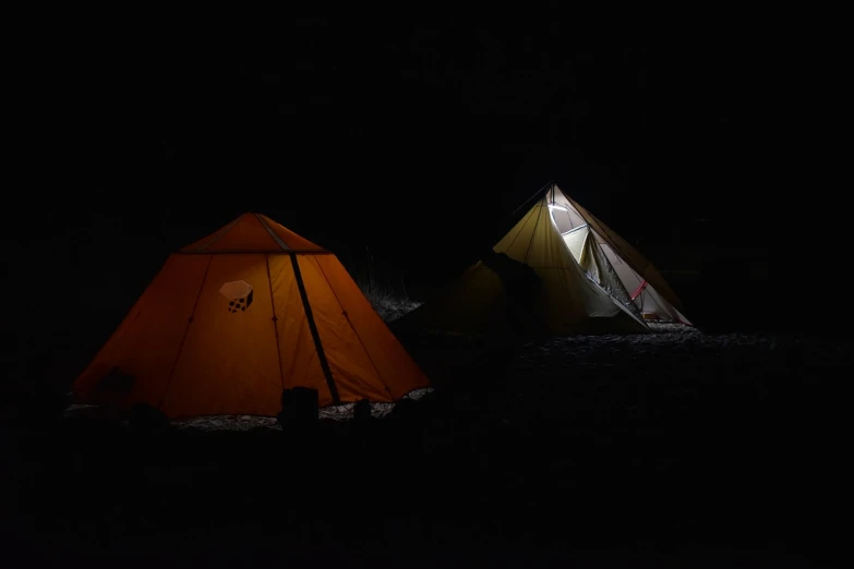 a couple of tents are lit up in the dark, hurufiyya, difraction from back light, high res photo