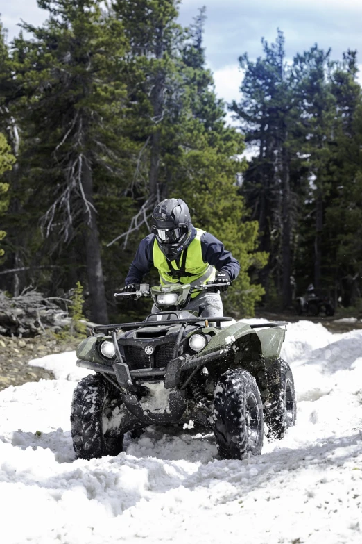 a man riding an atv in the snow, a photo, by Tom Palin, shutterstock, full body armor, yosemite, green, tv show still