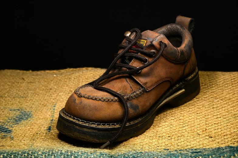 a close up of a shoe on a rug, a portrait, trending on pixabay, caramel. rugged, worksafe.1990s, against dark background, creepers