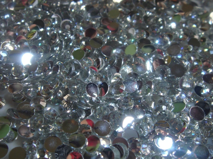 a pile of glass beads sitting on top of a table, a macro photograph, by Jon Coffelt, flickr, crystal cubism, glittering silver ornaments, shiny skin”, très détaillé, y2k”