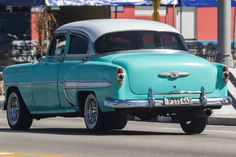 a blue and white car driving down a street, a colorized photo, by Jay Hambidge, pixabay contest winner, swagger! lowrider culture, seafoam green, perfect crisp sunlight, 2 tone colors only
