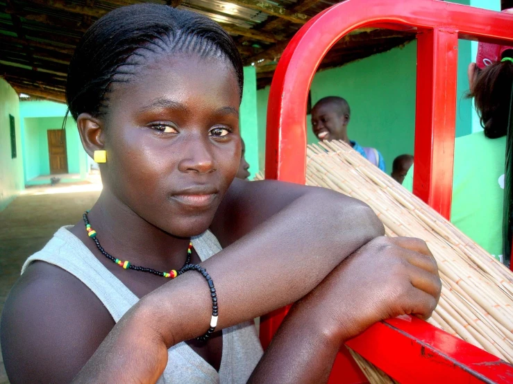 a young girl sitting on the back of a red truck, flickr, afrofuturism, in a village, closeup photo, 2009), beautiful women