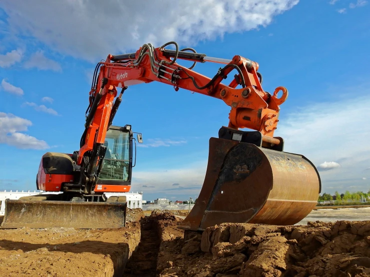 a large orange excavator sitting on top of a pile of dirt, shutterstock, wide angle dynamic action shot, repairing the other one, dlsr photo, monitor