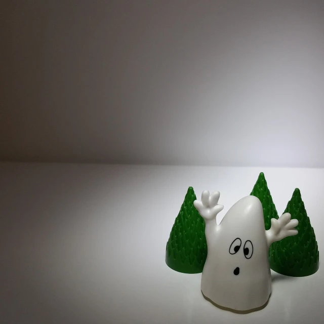 a close up of a figurine of a ghost with trees in the background, minimalism, white background!!!!!!!!!!, in a candy forest! at night, pov photo, tooth