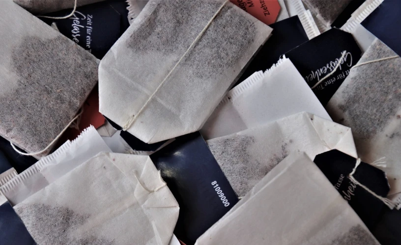 a pile of tea bags sitting on top of each other, a screenshot, by Magdalene Bärens, unsplash, pouches, field notes, close up view, light and dark