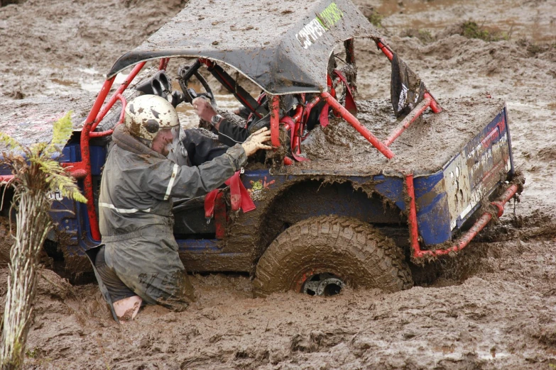 a man that is sitting in the back of a truck, by Robert Brackman, flickr, auto-destructive art, stuck in mud, all terrain vehicle race, in an arena pit, ultra 4k