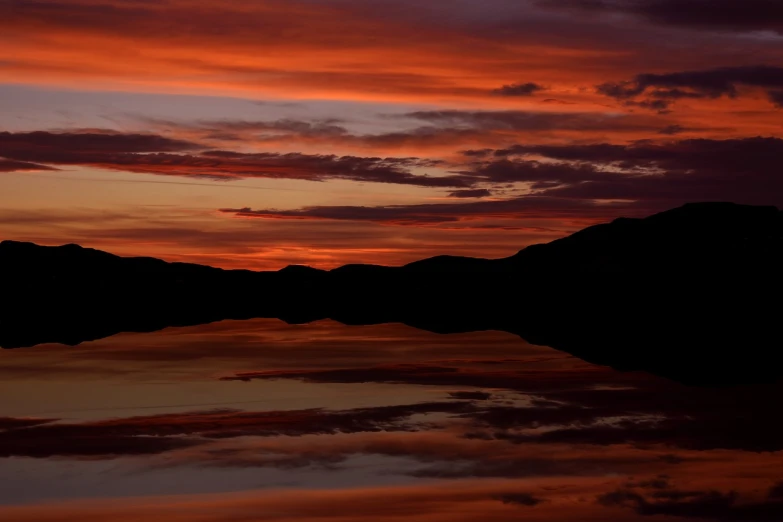 a large body of water with a sunset in the background, a photo, by Linda Sutton, shutterstock, red on black, reflecting, skye meaker, predawn