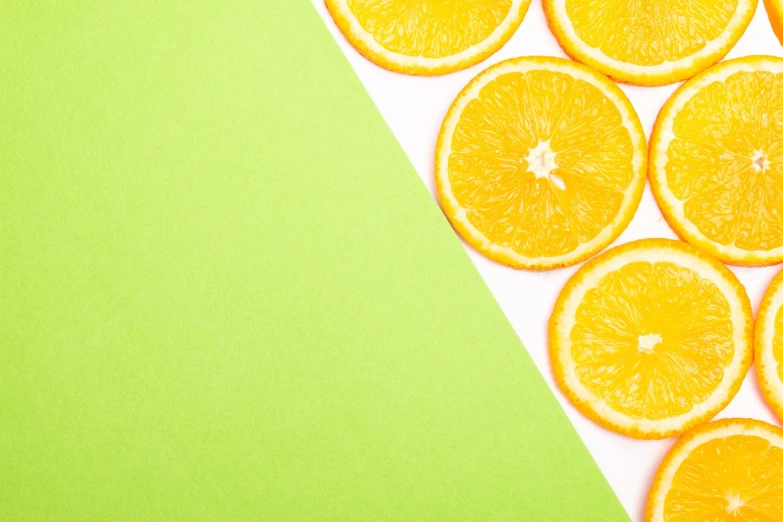 a group of orange slices sitting on top of a piece of paper, a stock photo, postminimalism, green and yellow colors, background image, product photo