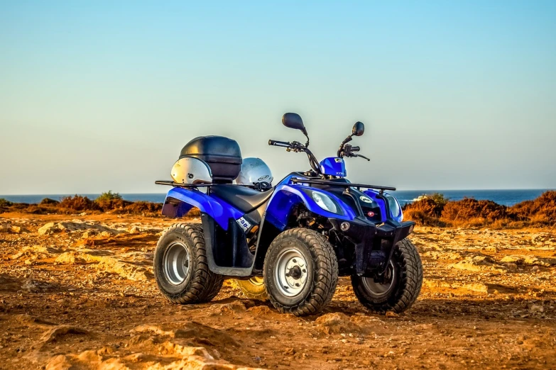 a couple of atvs that are sitting in the dirt, a portrait, by Julian Allen, shutterstock, near the sea, sky blue, backlit, sapphire