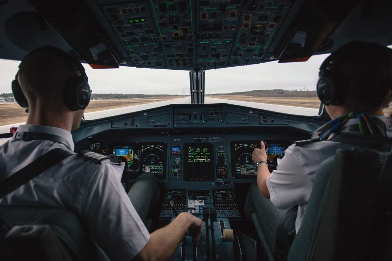 a couple of pilots sitting in the cockpit of a plane, shutterstock, distance shot, foam, runway photo, very accurate photo