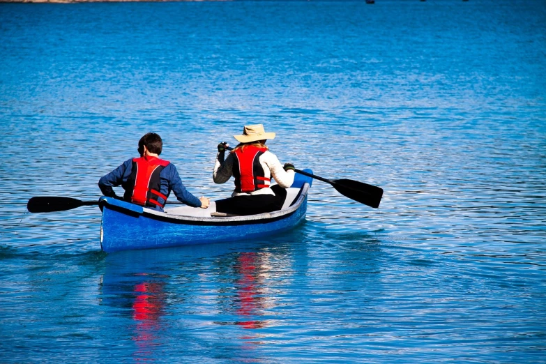 a couple of people that are in a boat, a photo, by Jan Rustem, shutterstock, blue and red color scheme, california;, telephoto shot, paddle of water