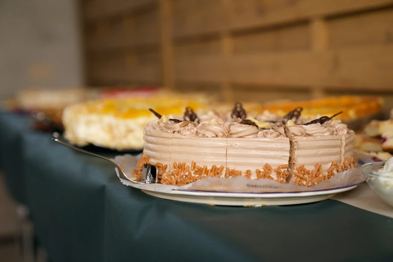 a table topped with a cake covered in frosting, a picture, by Aleksander Gierymski, shutterstock, event photography, brown, close up shot from the side, italian