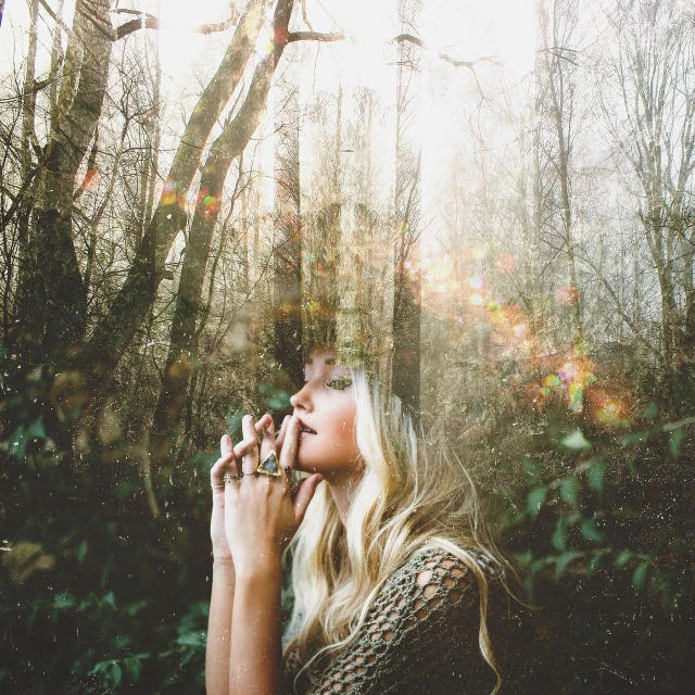 a woman smokes a cigarette in the woods, unsplash, aestheticism, with lots of glittering light, blonde women, double exposure of love, vsco film grain