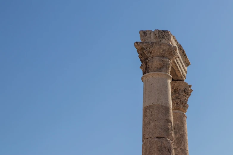 a tall column with a clock on top of it, neoclassicism, in ancient city ruins, middle eastern details, clear blue sky, taken with sony a7r camera