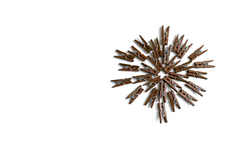 a clock made out of clothes pegs on a white surface, a photo, minimalism, snowflakes, brown, very sharp photo, illustration