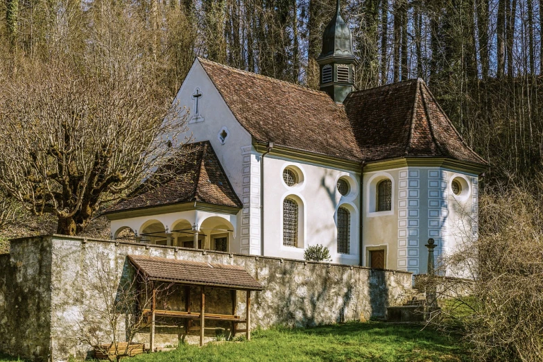 a white building sitting on top of a lush green hillside, by Otto Meyer-Amden, renaissance, church in the wood, the narthex, tradition, suzanne engelberg