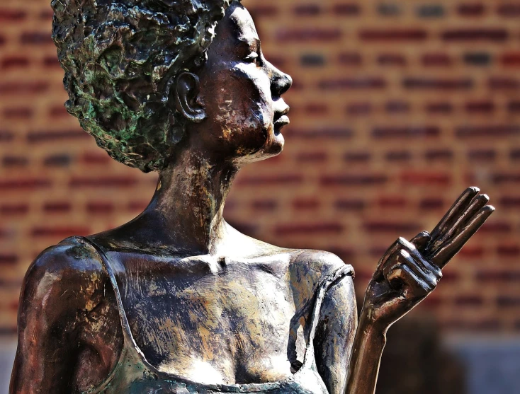 a statue of a woman holding a cell phone, a bronze sculpture, by Hubert van Ravesteyn, pexels, afrocentric mysticism, detailed expression, beautiful lines, artistic depiction