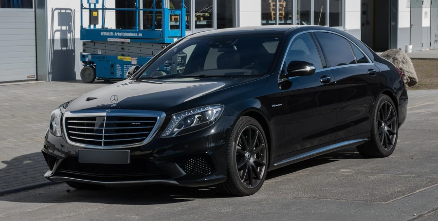 a black car parked in front of a building, by Thomas Häfner, mercedez benz, pristine and clean, front and side view, in 2 0 1 5