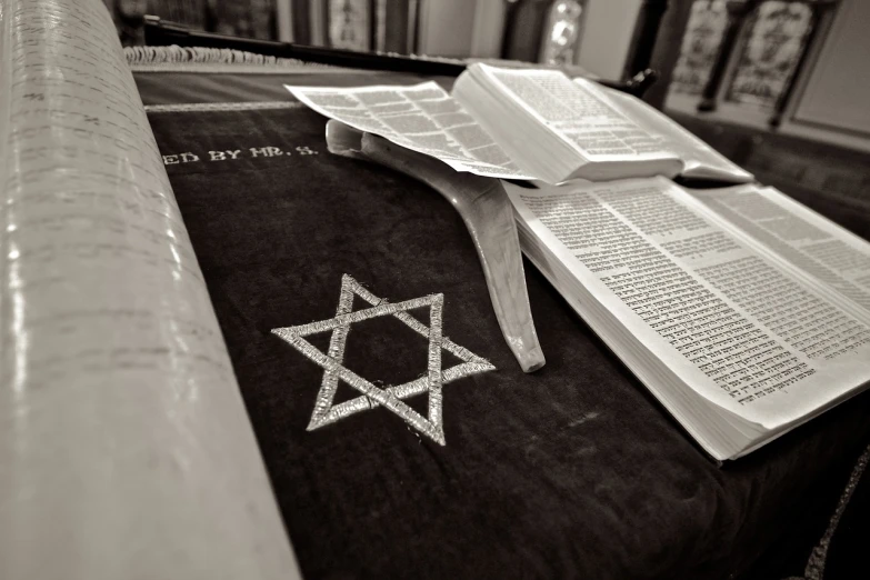 an open book sitting on top of a table, an engraving, by Emanuel Witz, unilalianism, star, ian david soar, black and white picture, in a sanctuary