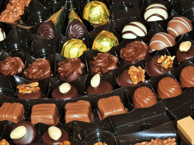 a tray of chocolates sitting on top of a table, by Susan Heidi, pexels, assemblage, lots of detail, chocolate candy bar packaging, wining, !!highly detailed!!