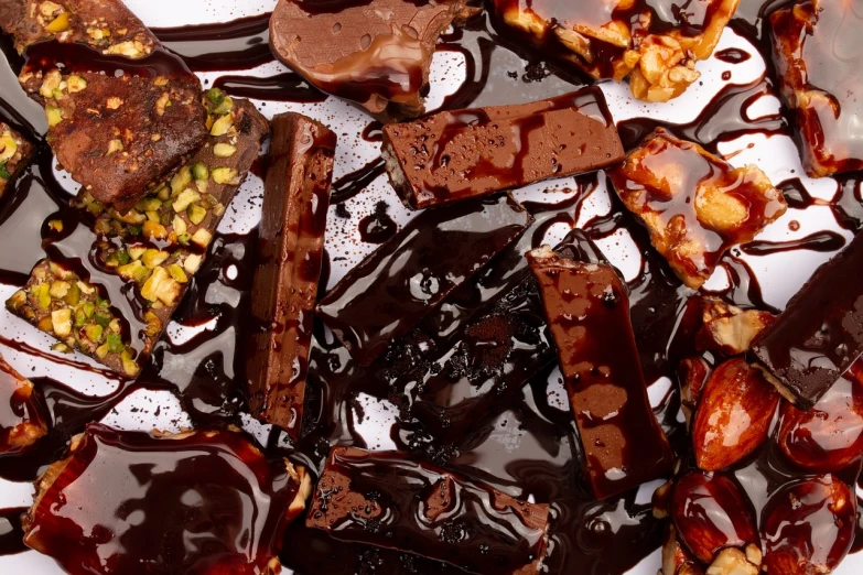 a white plate topped with chocolate and nuts, a picture, pexels, baroque, abstract black oil, closeup 4k, lacquered glass, stained”