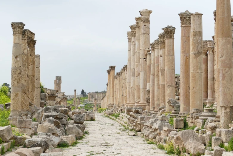 a group of stone pillars standing next to each other, by Steven Belledin, shutterstock, neoclassicism, in ancient city ruins, natural stone road, very wide wide shot, al - qadim