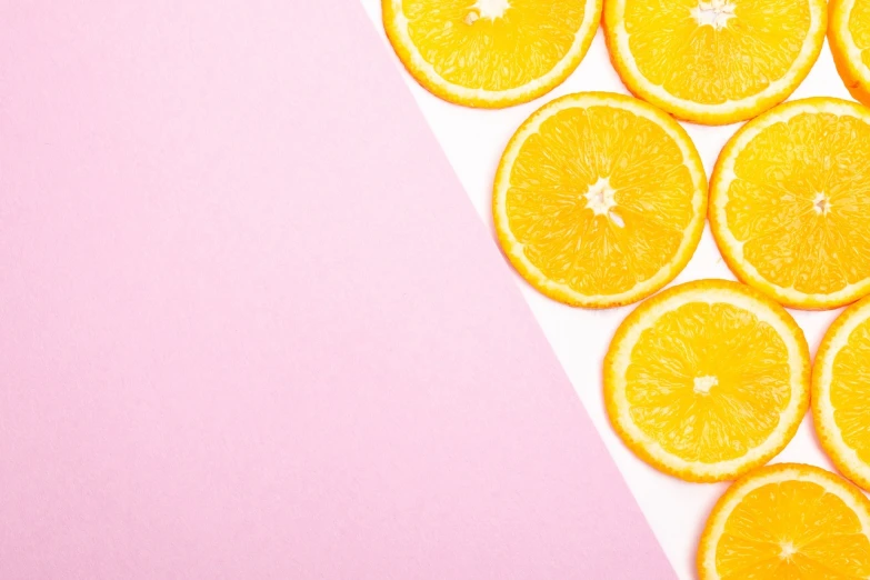 a close up of sliced oranges on a pink and white background, postminimalism, 🐿🍸🍋, background image, yellow wallpaper, miniature product photo