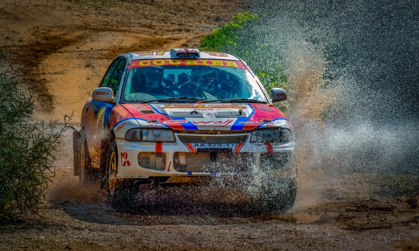a red, white, and blue truck driving on a dirt road, a photo, by Ivan Grohar, rally car, wet hdr refractions, podium, raining