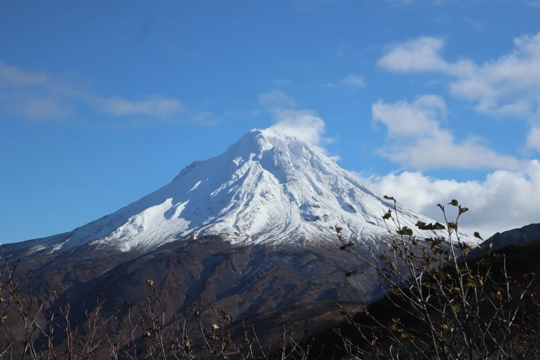 a snow covered mountain with trees in the foreground, a picture, inspired by Kōno Michisei, flickr, hurufiyya, mount doom, clear day, today\'s featured photograph 4k, andes