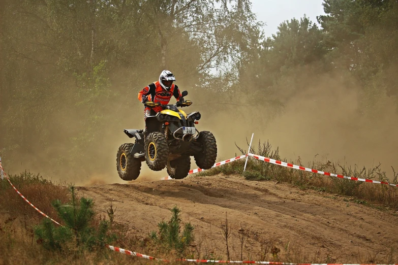 a man riding on the back of a dirt bike, a photo, by Dietmar Damerau, shutterstock, all terrain vehicle race, black and yellow and red scheme, in a race competition, photo photo