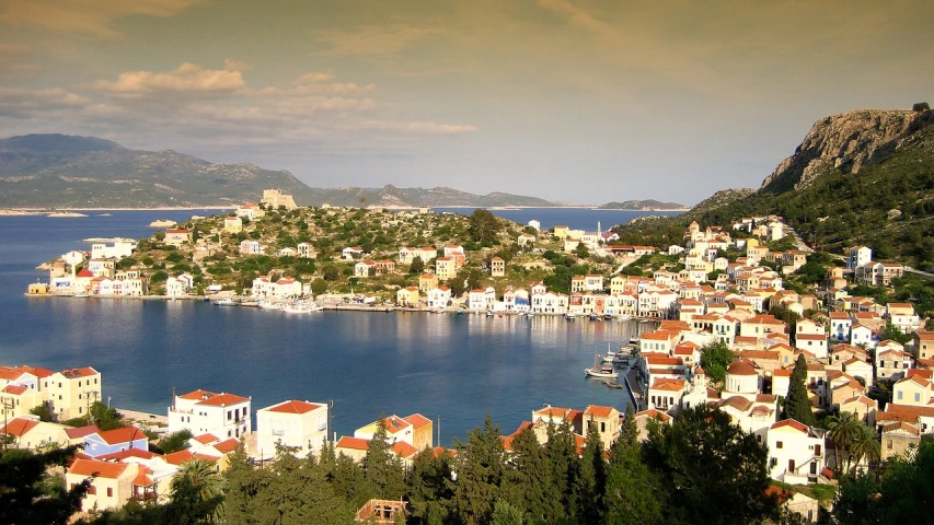 a town sitting on top of a hill next to a body of water, by Mathias Kollros, flickr, greek style, cutest, lagoon, watch photo