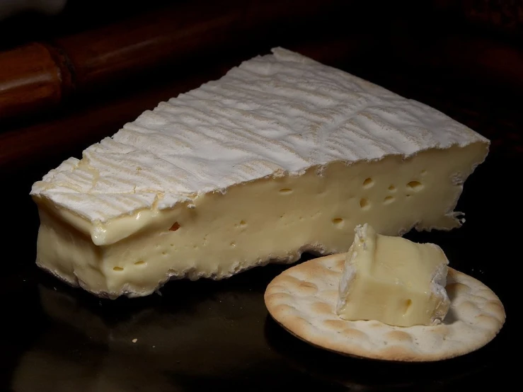 a piece of cheese and crackers on a table, a portrait, by François Girardon, pixabay, art nouveau, ivory carved ruff, against a deep black background, soft white glow, close-up shot