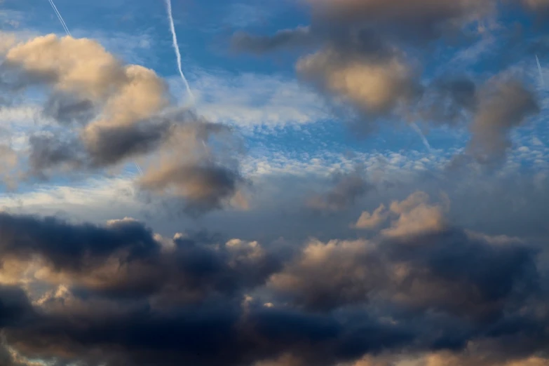 a plane flying through a cloudy blue sky, by Hans Schwarz, precisionism, evening storm, today\'s featured photograph 4k, 4k vertical wallpaper, big smoke clouds visible