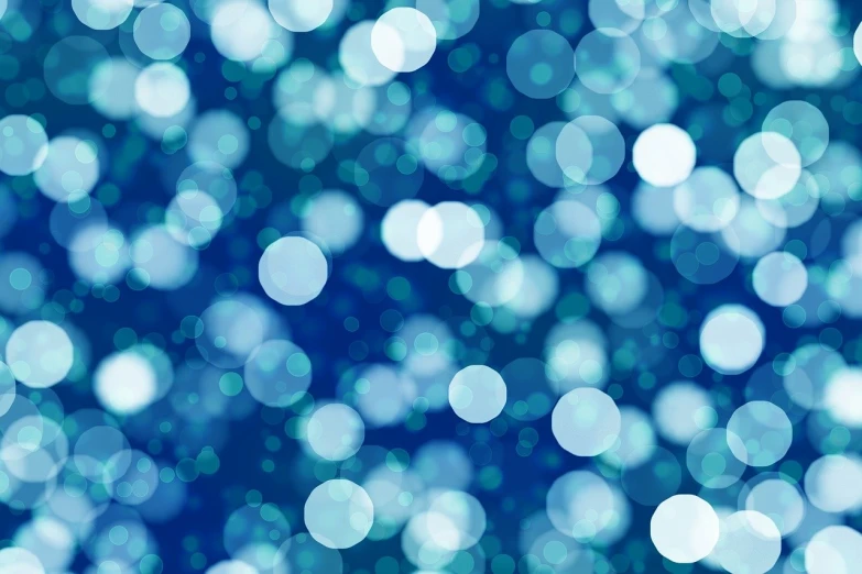 a close up of a blue bokeh background, inspired by Yves Klein, shutterstock, pointillism, white sparkles everywhere, illuminated orbs, bokeh photo