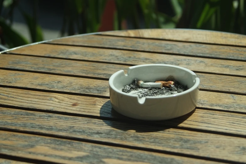 a white ashtray sitting on top of a wooden table, pixabay, hyperrealism, perfect crisp sunlight, deck, smoker, istock