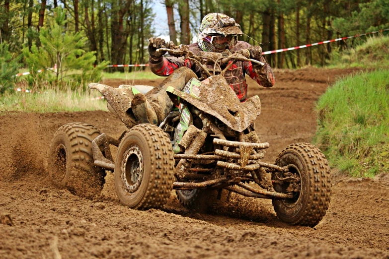 a man riding on the back of a dirt bike, a photo, by Aleksander Gierymski, shutterstock, all terrain vehicle race, covered in mud, winning photo, underbrush wash