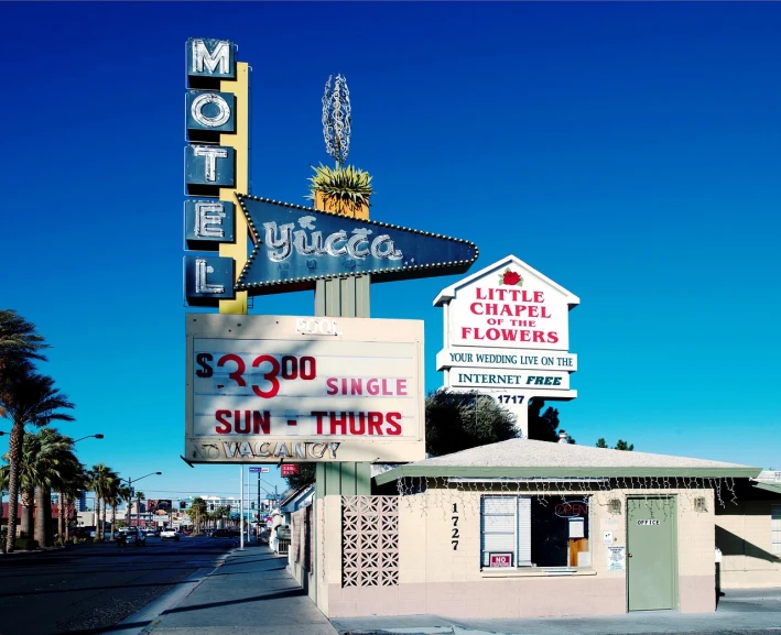 a motel sign sitting on the side of a road, by Mike Bierek, dada, in a las vegas street, flowers, tiffany dover, niels otto møller