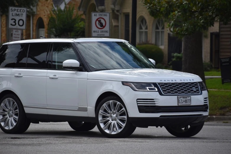 a white range rover parked on the side of the road, by Tom Carapic, renaissance, trimmed with a white stripe, j. h. williams iii, taken with canon 8 0 d, front side full