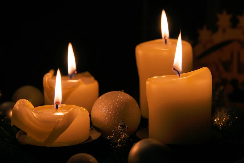 a group of lit candles sitting on top of a table, a photo, flickr, baroque, emitting light ornaments, dark background ”, watch photo, orb