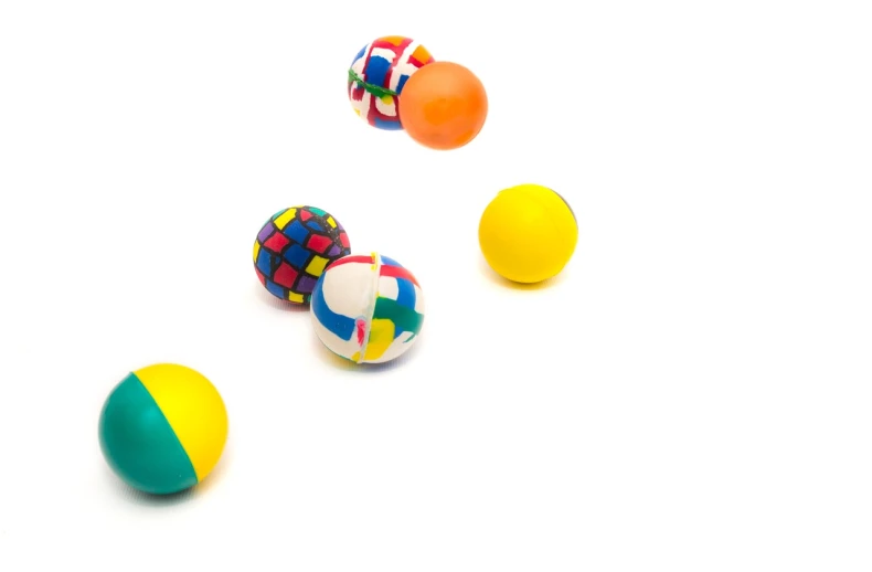a group of colorful balls sitting on top of a white surface, dribble, product photograph, miniature product photo, bouncing, rubber