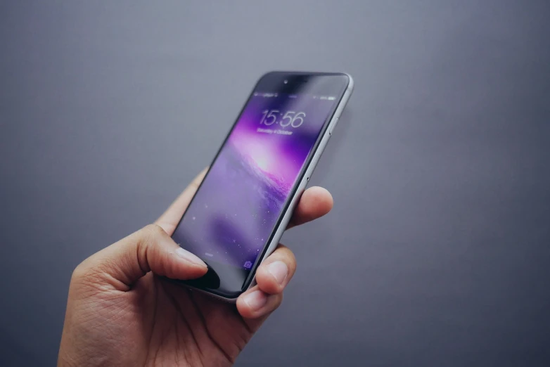 a person holding a cell phone in their hand, by Niko Henrichon, pexels, realism, violet colored theme, shot on iphone 6, stunning screensaver, slightly realistic