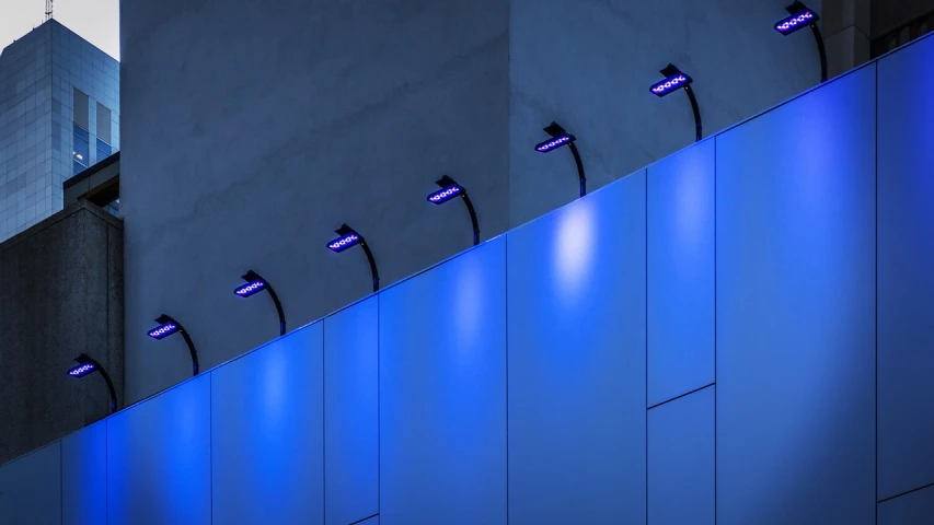 a group of lights that are on the side of a building, by Jan Rustem, unsplash, conceptual art, blue wall, purple and blue leather, minimalistic architecture, led lamps