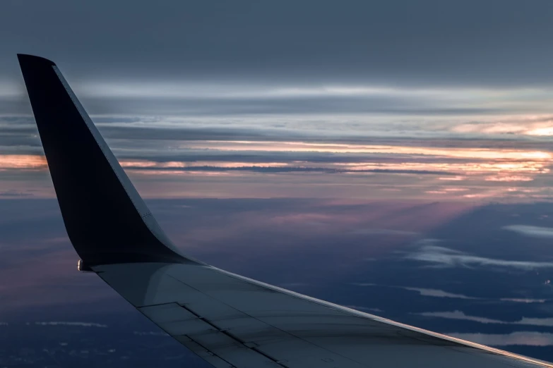 the wing of an airplane as the sun sets, by Raymond Normand, precisionism, overcast dawn, trim, michael bair, vacation photo