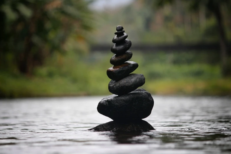 a stack of rocks sitting on top of a body of water, a statue, minimalism, stepping stones, black rock statue material, treading above calm water, a mystic river