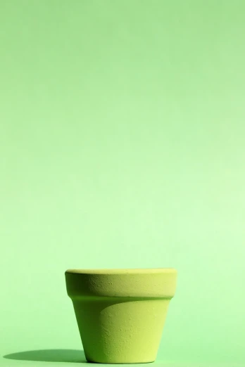 a yellow flower pot sitting on a green surface, by Peter Alexander Hay, minimalism, abstract claymation, lightgreen, wallpaper - 1 0 2 4, kitchen background