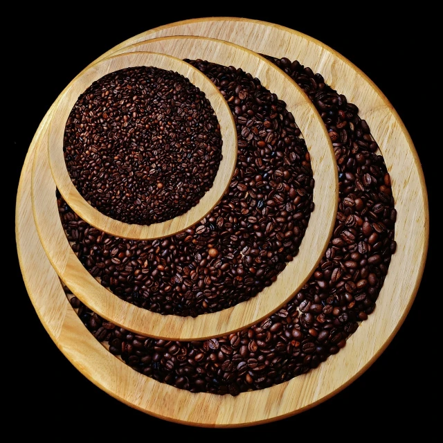 a pile of coffee beans sitting on top of a wooden plate, a digital rendering, by Jon Coffelt, kinetic pointillism, on black background, product photo, crop circles, high quality product photo