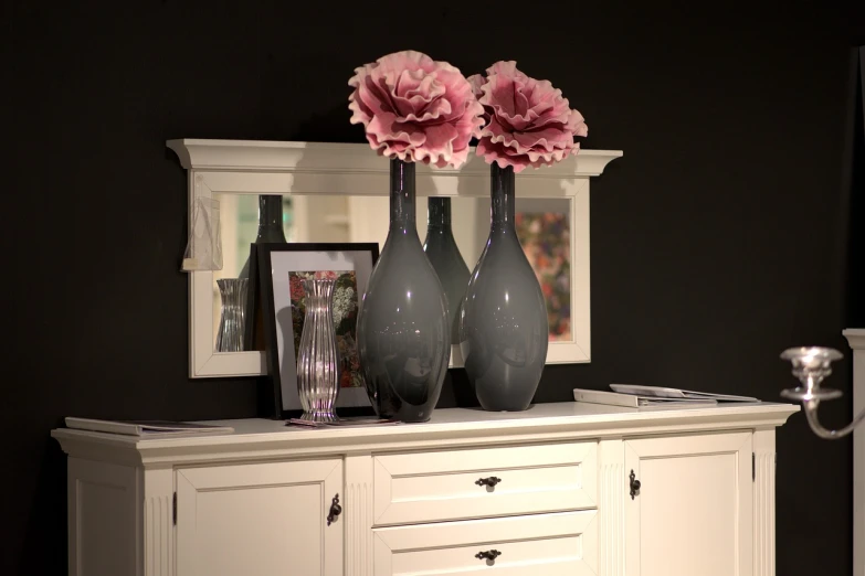 a couple of vases sitting on top of a dresser, a pastel, by Karl Pümpin, pixabay, black peonies, black show room, pink accents, grey color scheme