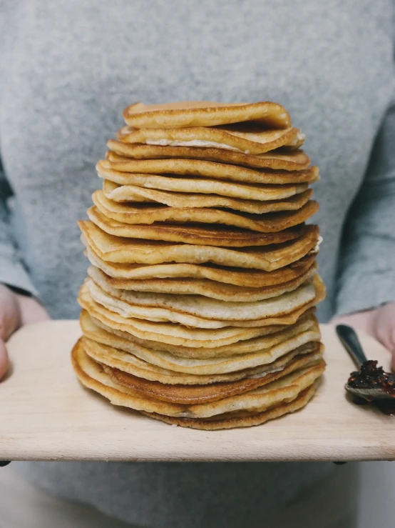 a stack of pancakes sitting on top of a wooden board, a portrait, by Emma Andijewska, unsplash, lots of wrinkles, thicc build, edible crypto, group photo