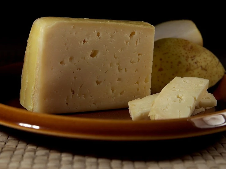 a piece of cheese sitting on top of a brown plate, a portrait, by Adam Chmielowski, flickr, spanish, apple, very sharp and detailed image, screensaver