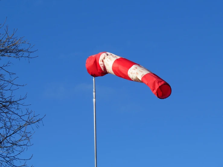 a red and white kite flying in a blue sky, inspired by Jan Rustem, flickr, figuration libre, tomato hat and a walking stick, windstorm, hoog detail, winter sun